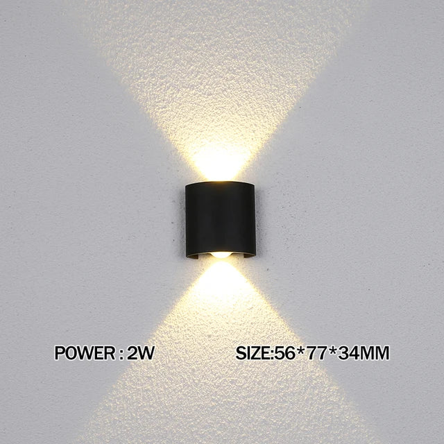 Black wall-mounted light fixture on a gray wall with text indicating power and size.