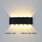 Black wall-mounted light fixture on a gray wall with text indicating power and size.