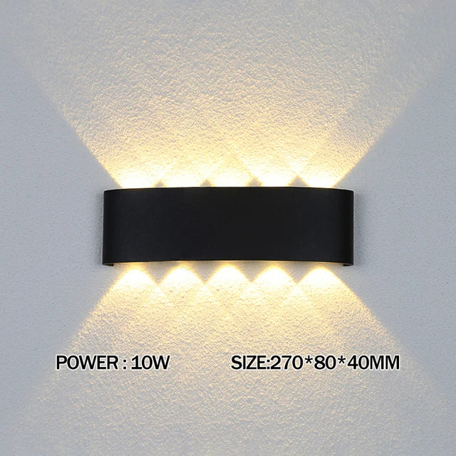 Black wall-mounted light fixture on a gray wall with text indicating power and size.