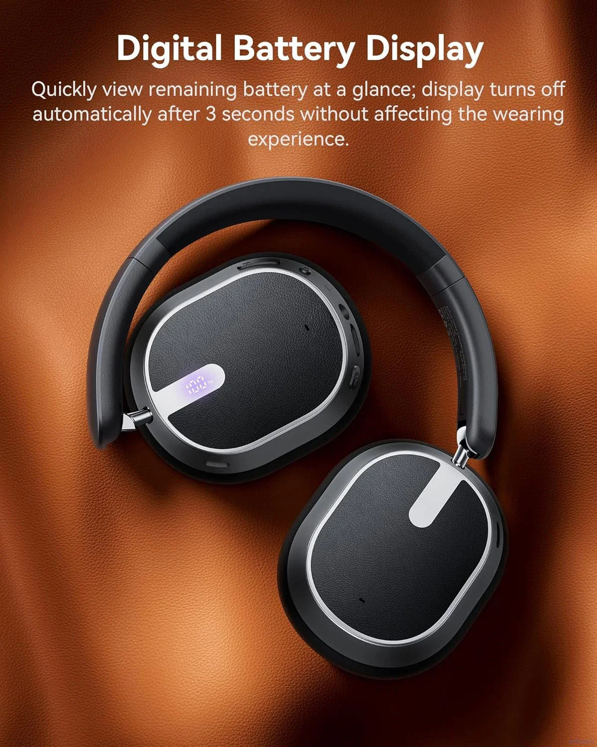 Black headphones with digital battery display on a brown leather background