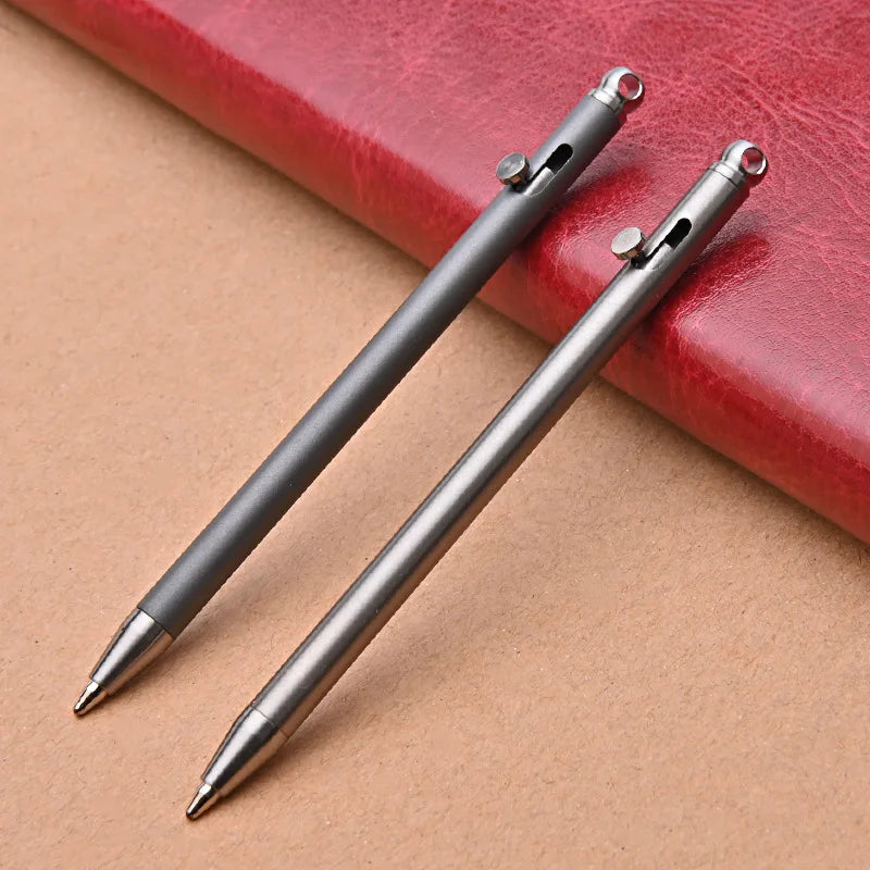 Two metallic pens on a red leather surface