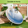 Solar stove with a kettle on a grassy area with a wooden deck background