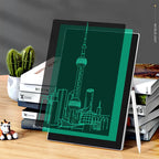 Tablet with a green screen displaying a cityscape on a wooden surface with books and a plant.