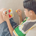 Child playing with a colorful toy on a beige couch