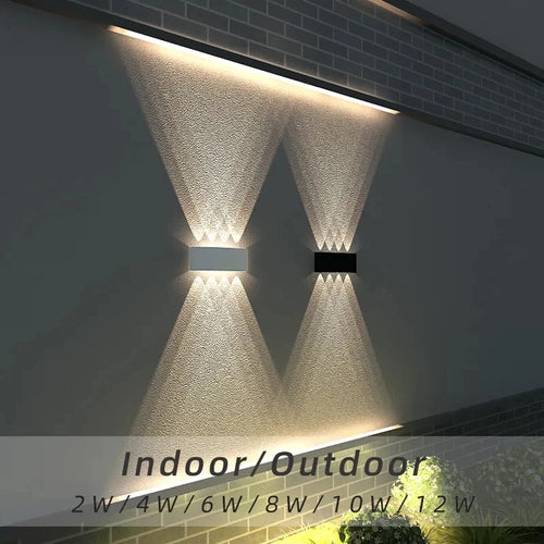 Two outdoor wall lights on a building facade with text indicating wattage options.